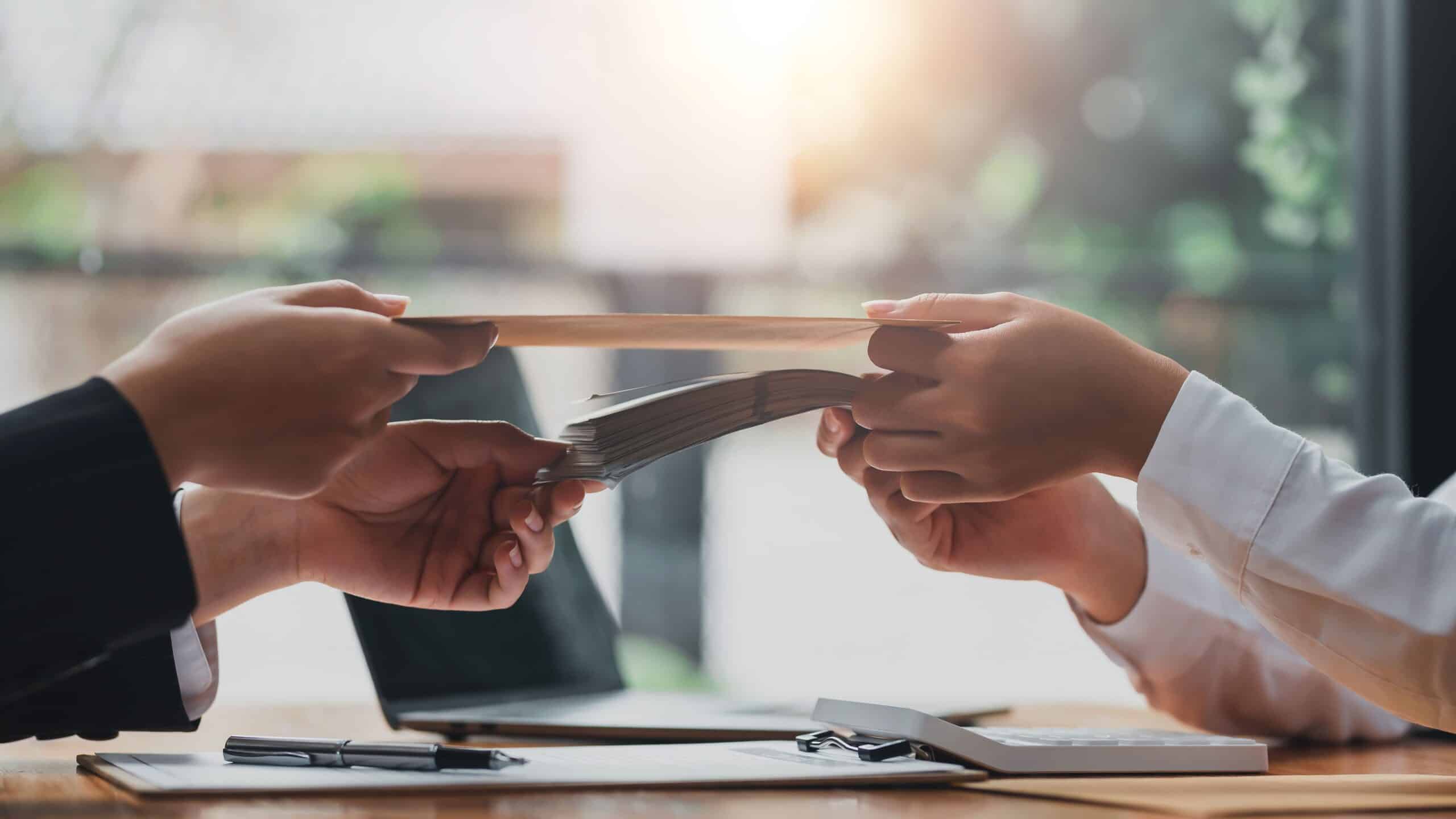 Two hands exchanging a document in an office