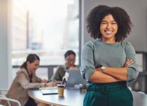 Confident woman smiling at office meeting.