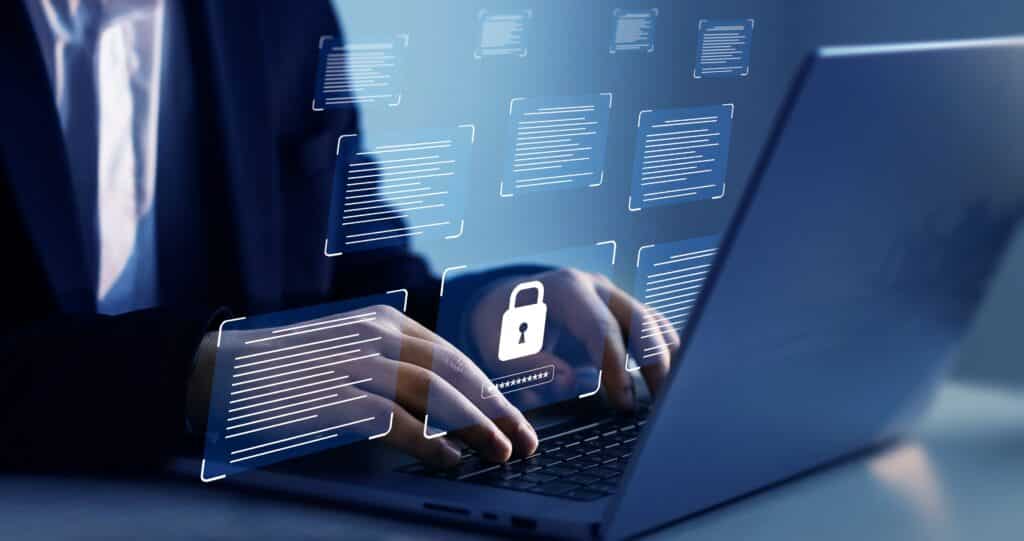 Person typing on a laptop with security graphics