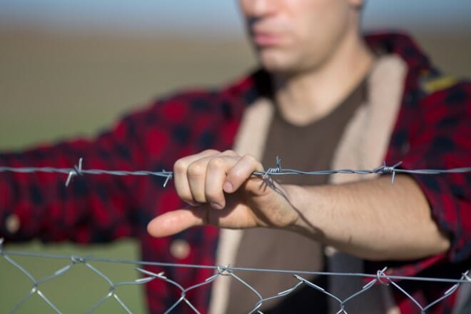 man holding barbed wire