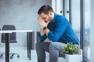 Stressed man sitting by office window.