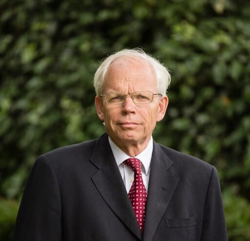 Man in a suit standing outdoors.