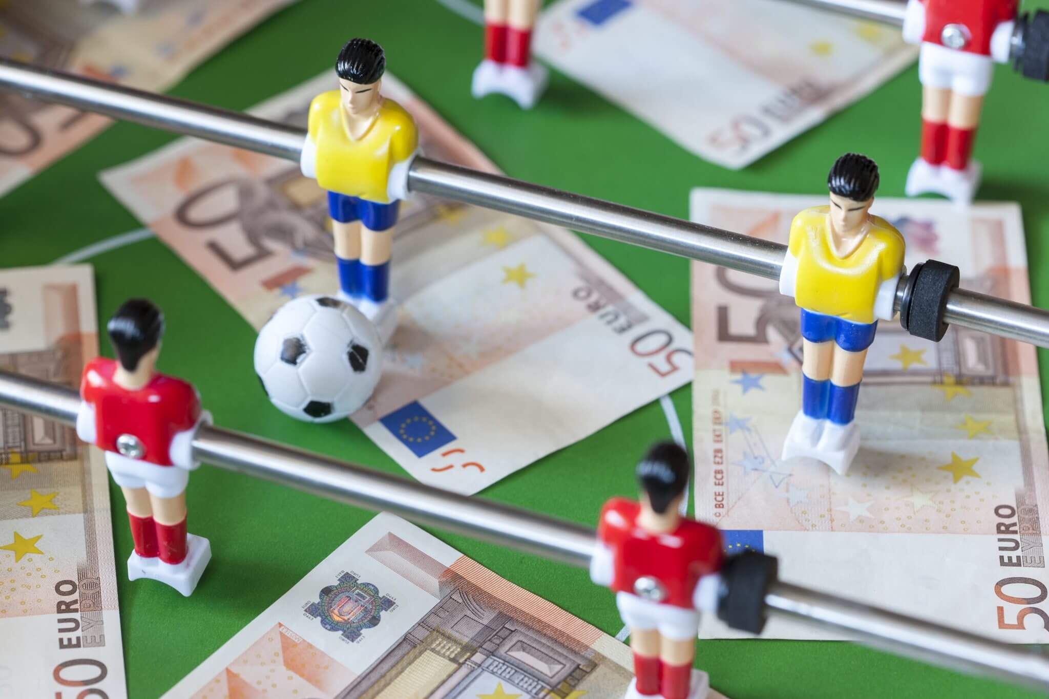 close up of table football with money underneath the players