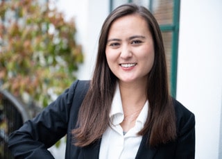 Smiling woman in business attire outdoors.