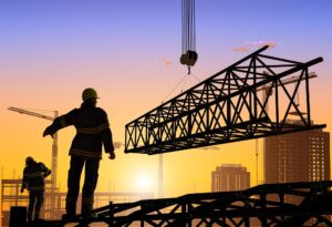 Construction workers at sunrise with crane.