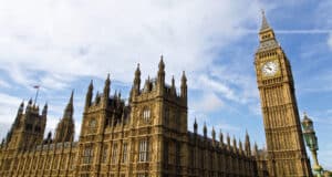 Big Ben with Westminster Palace under blue sky.