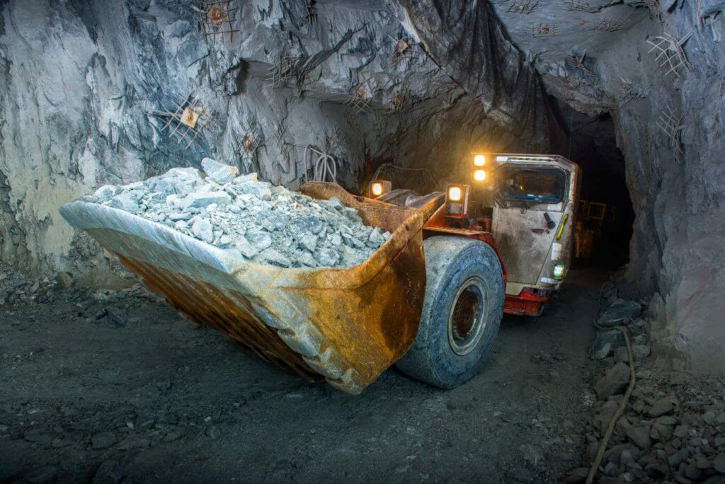 A mining truck loaded with rocks in a tunnel.