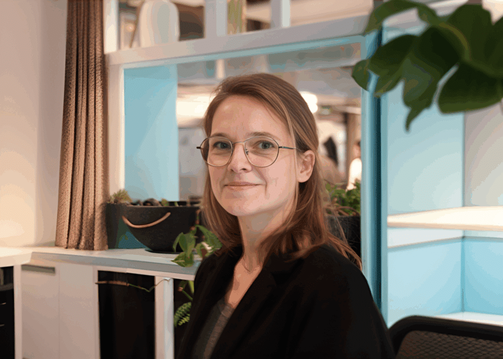 Smiling woman in a modern office setting.