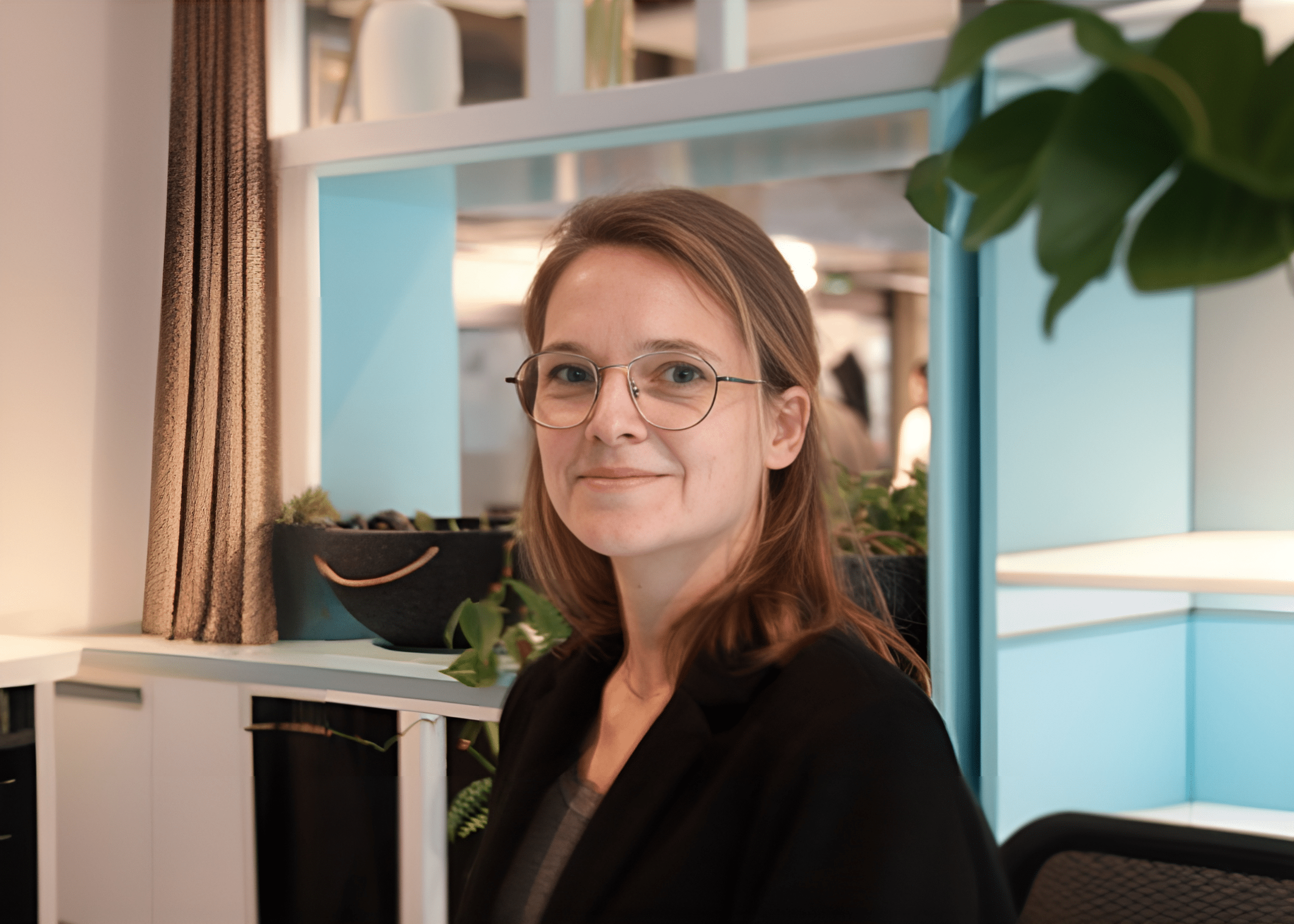 Smiling woman in a modern office setting.