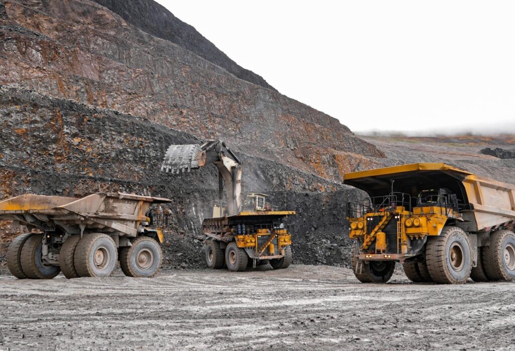 Mining trucks and excavator in open-pit mine
