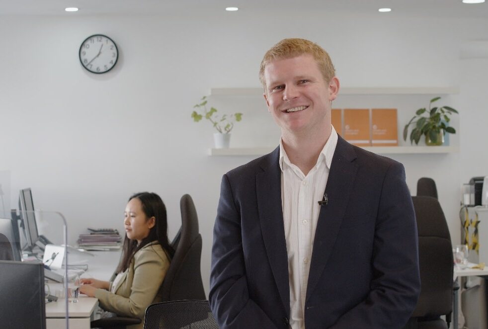 Professional man smiling in modern office environment.