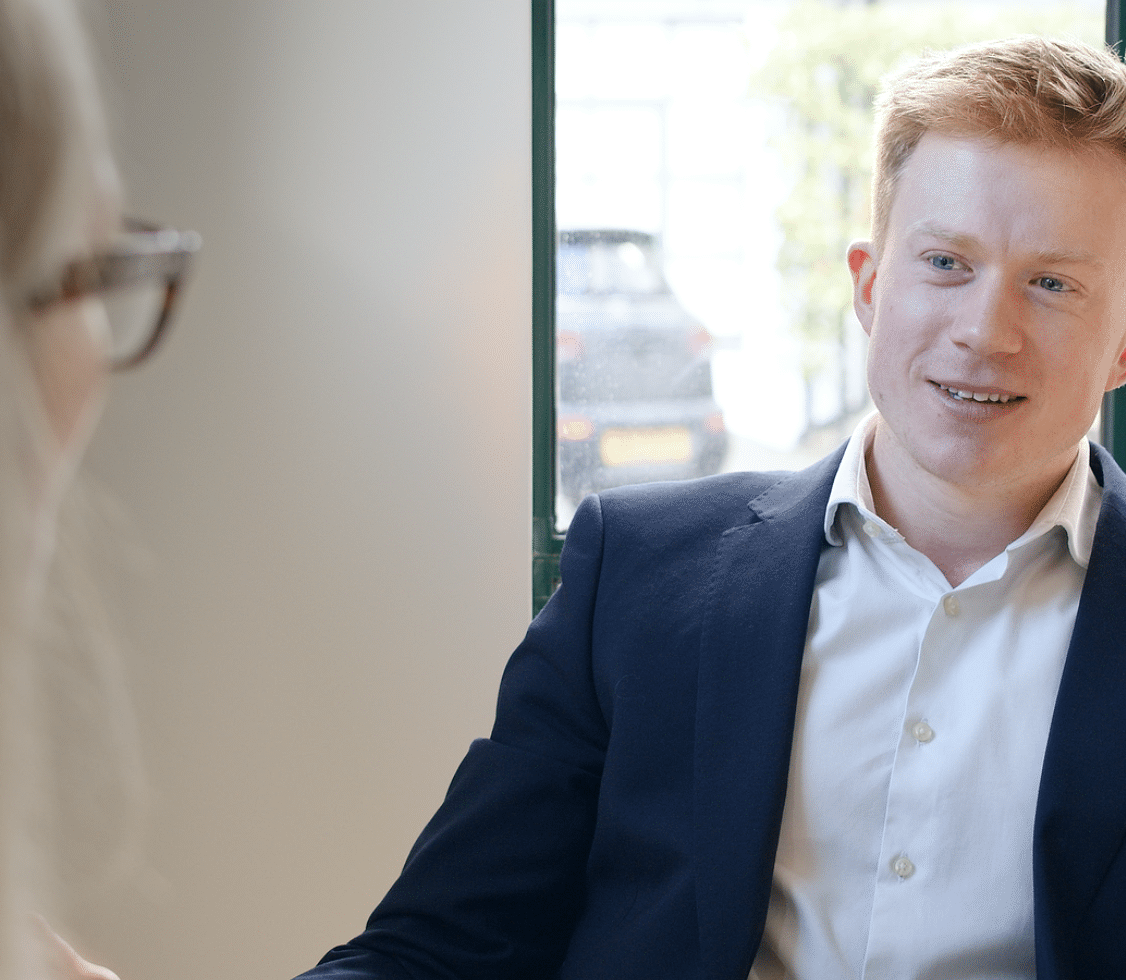 Two people engaged in a conversation indoors.