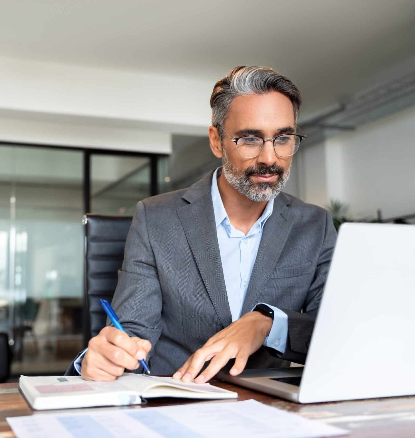 Businessman working on laptop in modern office.