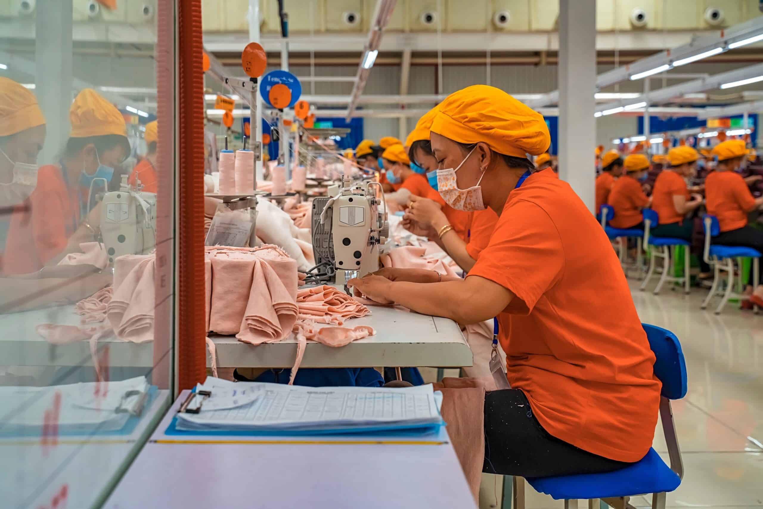 Workers sewing fabric in a garment factory.