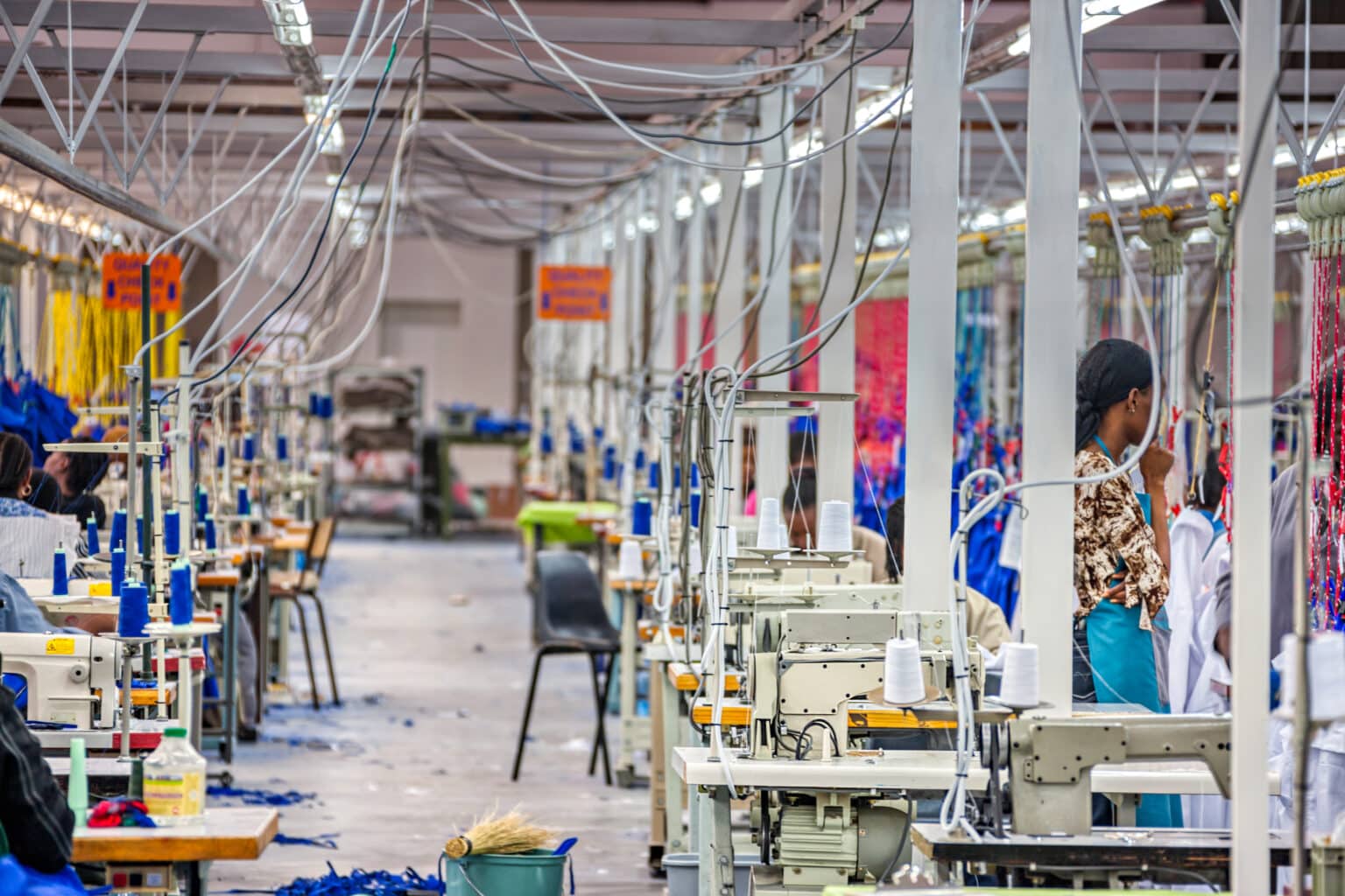 Workers in a textile factory with sewing machines.