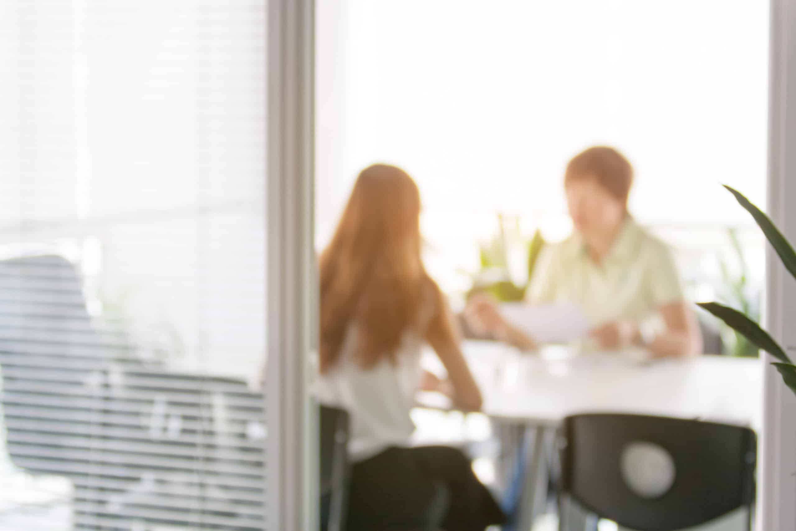 Two people discussing documents in an office.