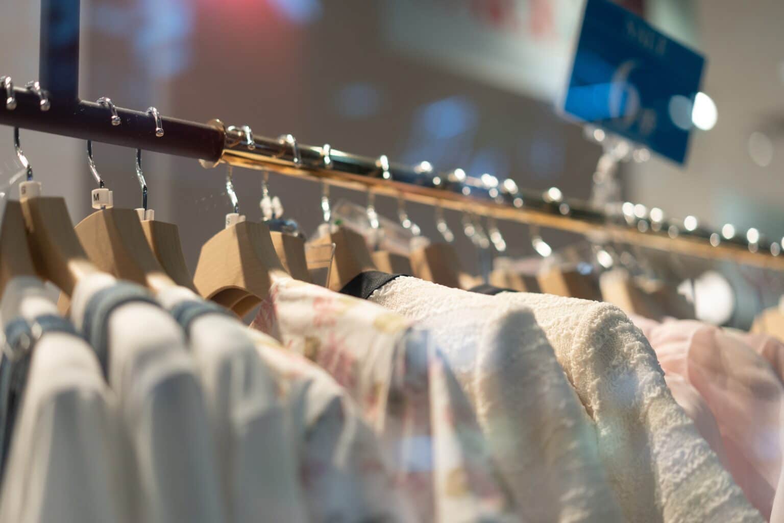 Clothes hanging on wooden hangers in a store.