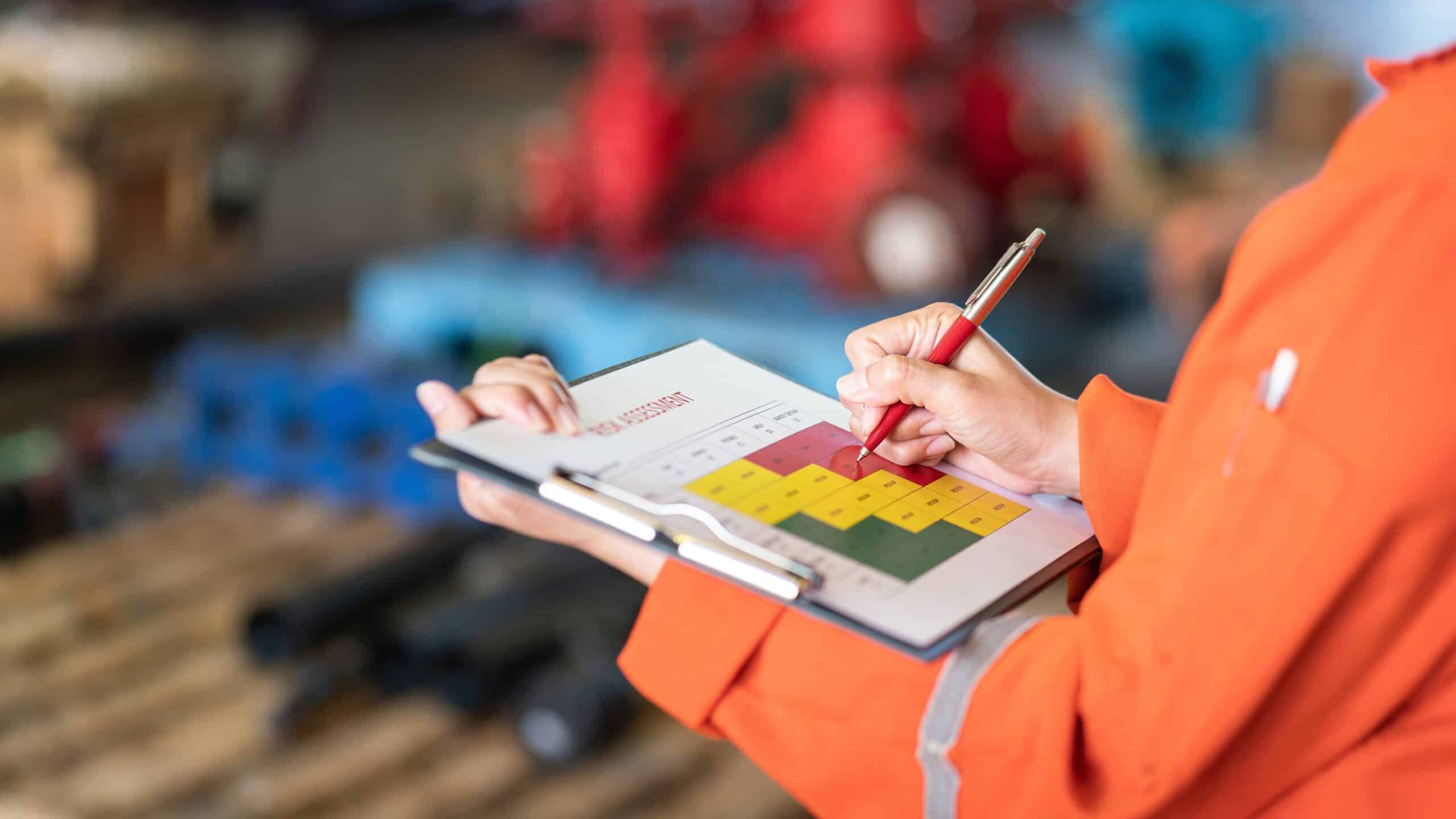 Worker inspecting checklist on clipboard in warehouse