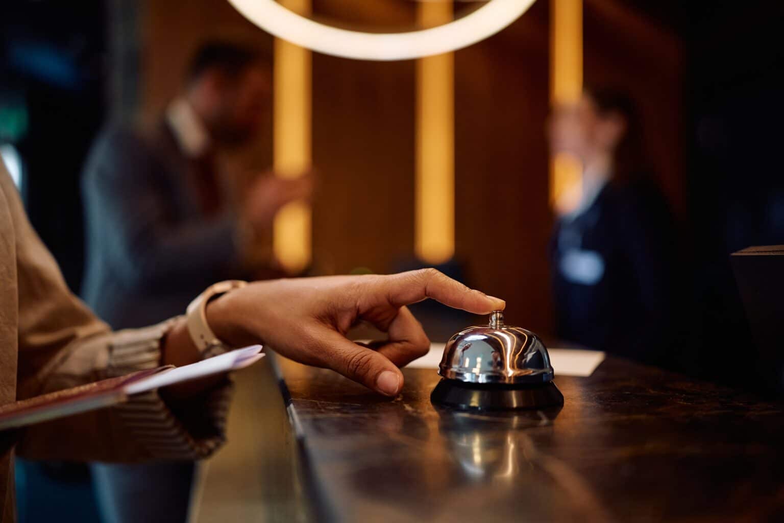 Guest ringing hotel reception desk bell