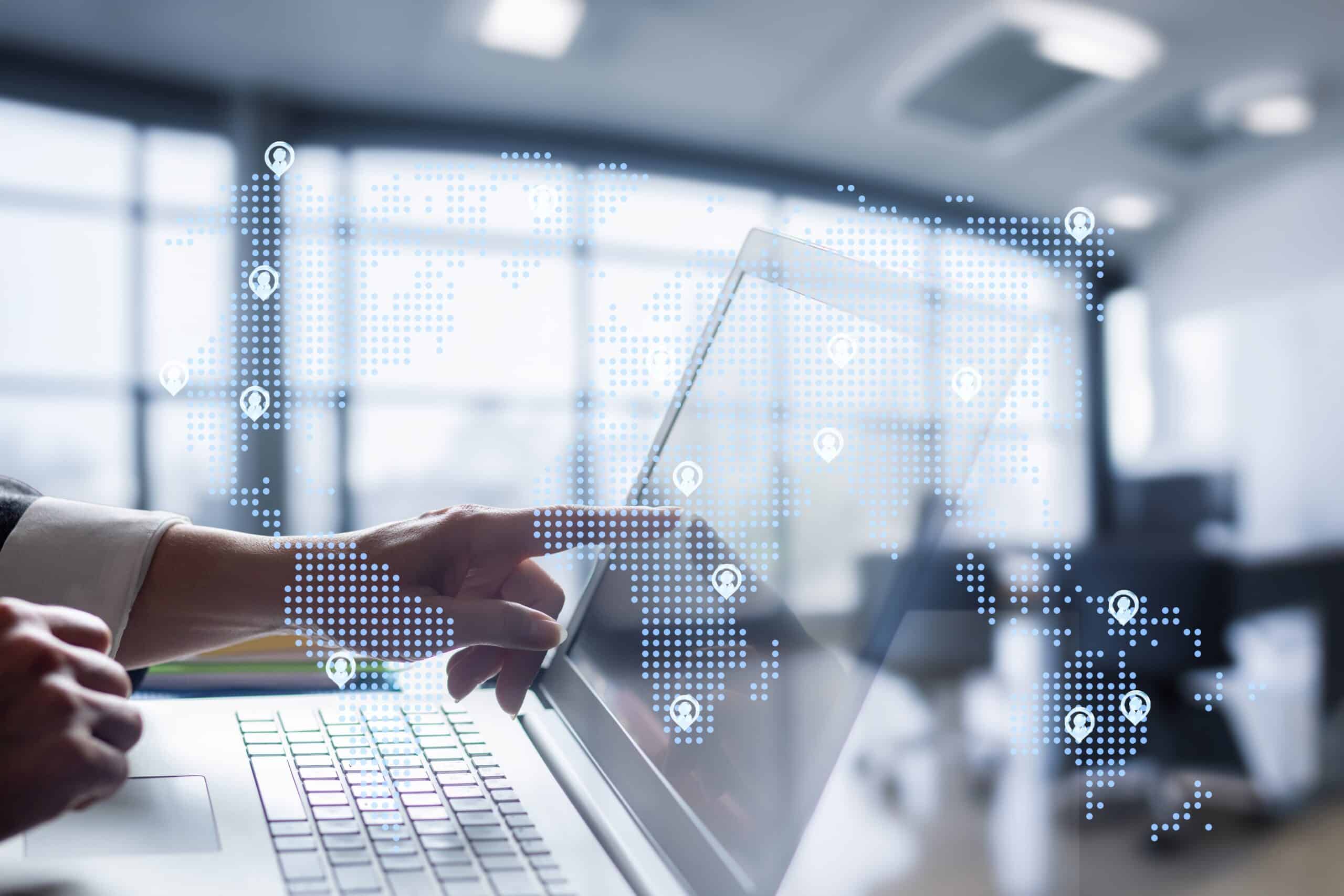 Person using laptop with global network map overlay