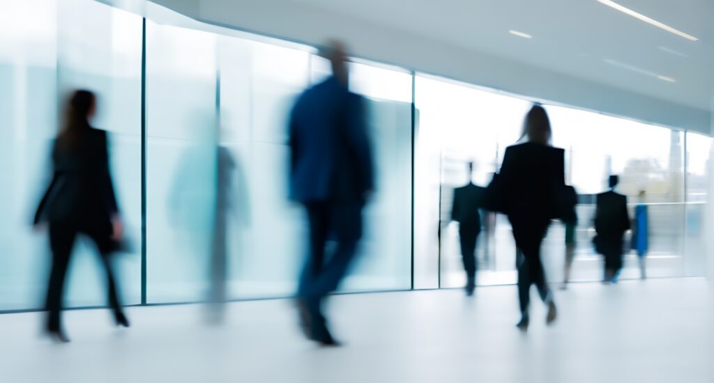 Blurred business professionals walking in modern office corridor